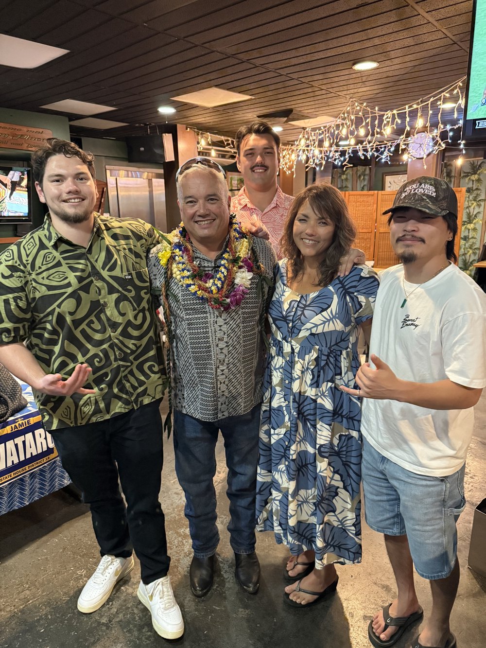 Jamie Wataru wearing leis with family at a celebration